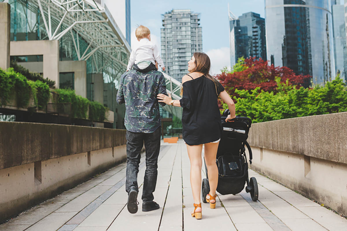 Young, cool family walking together with stroller – enjoying lif